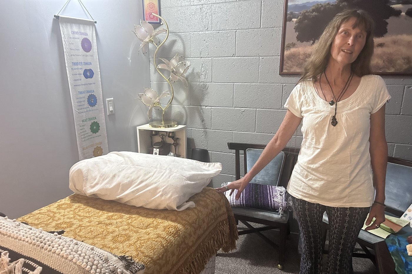 Danita Sayers beside the treatment table in her Reiki room