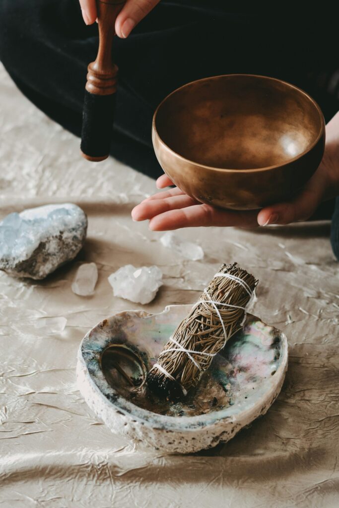 Crystals, a sage bundle and a singing bowl